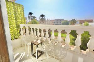 a balcony with white chairs and a white railing at White Gorf Hotel in Luxor