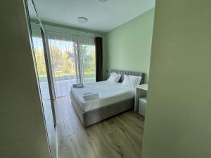 a bedroom with a bed and a large window at Hilltop Villa in Shetaj