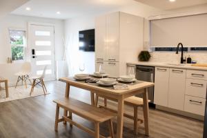 a kitchen with a wooden table with dishes on it at 2BDR Stylish Comfort Parkside in Vancouver