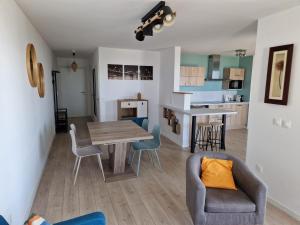 a living room and kitchen with a table and chairs at L'effet Mer de Stella in Stella-Plage