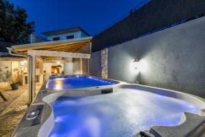 a jacuzzi tub in a backyard at night at Beachfront Luxury Villa in Vinišće