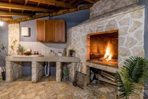 a kitchen with a stone fireplace and a sink at Beachfront Luxury Villa in Vinišće