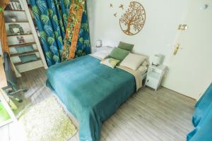 a bedroom with a bed with a blue blanket at La Suite de Richarville in Richarville