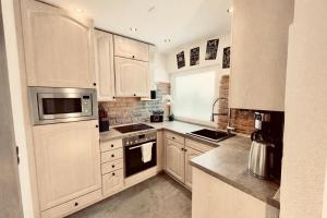 a kitchen with white cabinets and a stove top oven at unique Ferienwohnung in Leutkirch im Allgäu