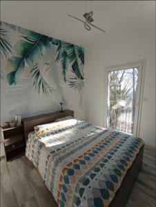a bedroom with a bed with a tropical wallpaper at Chambre proche Zénith et Centre ville in Nancy