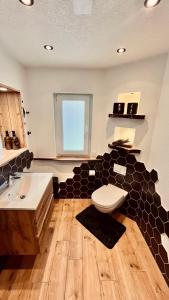 a bathroom with a black and white toilet and a sink at unique Ferienwohnung in Leutkirch im Allgäu +35 photos