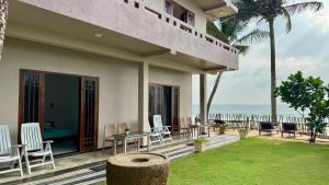 a resort with a table and chairs and the ocean at Vacation Beach in Hikkaduwa