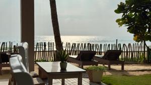 a patio with a table and chairs and the ocean at Vacation Beach in Hikkaduwa +31 photos