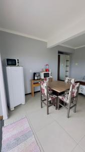 a kitchen with a table and chairs and a refrigerator at Kitnet beira da lagoa in Terra de Areia