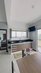 a kitchen with a dining table and a counter top at Kitnet beira da lagoa in Terra de Areia