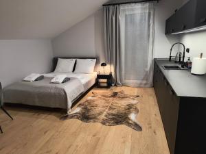 a bedroom with a bed and a kitchen with a table at Willa Górska Pasja in Szczyrk