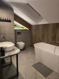 a bathroom with a tub and a sink and a toilet at Willa Górska Pasja in Szczyrk +44 photos