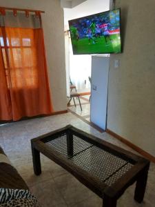 a living room with a tv and a coffee table at Tierra Nuestra in Villa Ciudad de América