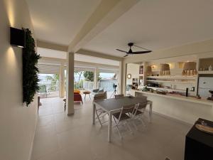 a kitchen and living room with a table and chairs at Villa exceptionnelle en bord de mer - SUNSET VILLA in Pointe-Noire