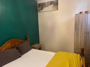 a bedroom with a bed and a green wall at STOCKTON CONTTRACTOR DIGs in Stockton-on-Tees