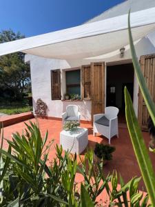 a patio with two chairs and a tent at Il Lentischio Casa 3 in Nulvi