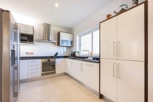 a kitchen with white cabinets and a sink at Infinity Penthouse in Lagos