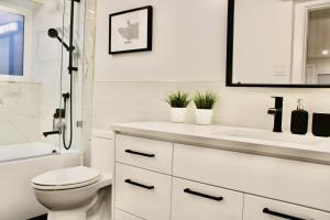 a white bathroom with a toilet and a sink at 2BDR Stylish Comfort Parkside in Vancouver +25 photos