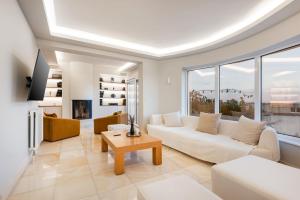 a living room with a white couch and a table at Villa Bijoux SeaView Pool near Athens airport in Neos Voutzas