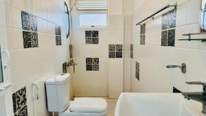 a bathroom with a toilet and a sink at Vacation Beach in Hikkaduwa