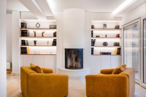 a living room with two chairs and a fireplace at Villa Bijoux SeaView Pool near Athens airport in Neos Voutzas