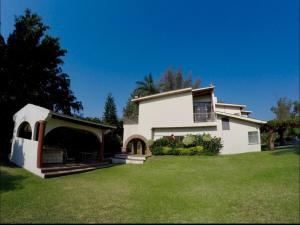 a large white house with a green yard at Casa Grande Lomas de Cocoyoc in Texcalpan