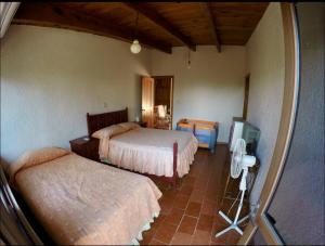 a bedroom with two beds and a tv in it at Casa Grande Lomas de Cocoyoc in Texcalpan +14 photos
