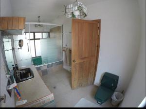 a small kitchen with a wooden door and a toilet at Casa Grande Lomas de Cocoyoc in Texcalpan