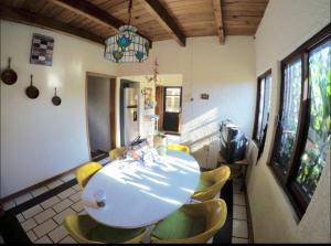 a dining room with a table and yellow chairs at Casa Grande Lomas de Cocoyoc in Texcalpan
