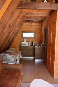 a kitchen in a log cabin with a bed in a room at Bungaja Chalets in Shkodër