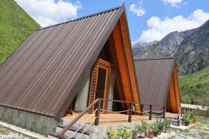 a house in the mountains with a brown roof at Bungaja Chalets in Shkodër
