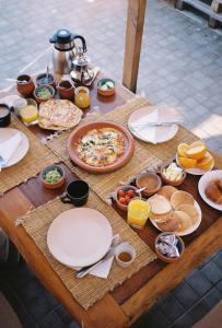a wooden table with plates and food on it at hyle Surfhouse in Agadir +22 photos