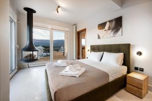 a bedroom with a large bed and a fireplace at Villa Bijoux SeaView Pool near Athens airport in Neos Voutzas +24 photos