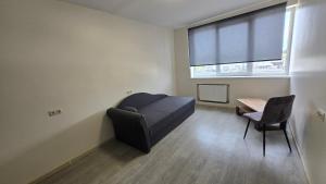 a room with a bed and a table and a window at Hostel istaba in Rēzekne +1 photo