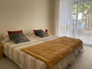 a bed in a bedroom with a large window at Villa exceptionnelle en bord de mer - SUNSET VILLA in Pointe-Noire