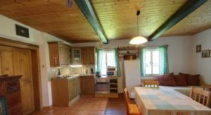 a kitchen and living room with a table and a dining room at Chalupa Žernovka in Žernov