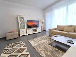 a living room with a couch and a tv at Tale Sunset Apartment in Lezhë +7 photos
