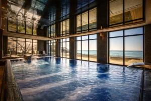 a large swimming pool with a view of the ocean at Apartament 330 Przy Plaży, parking gratis! in Międzyzdroje