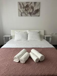 a bed with two towels on top of it at Tale Sunset Apartment in Lezhë