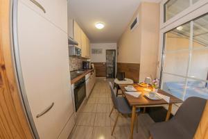 a kitchen and dining room with a table and chairs at Matrakapuvendeghaz in Mátraszőlős