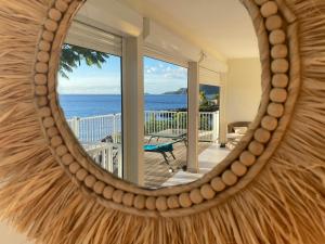 a mirror reflecting a room with a view of the ocean at Villa exceptionnelle en bord de mer - SUNSET VILLA in Pointe-Noire