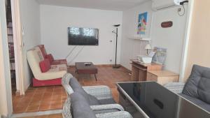 a living room with two couches and a tv at Montago in Le Gosier