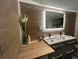 a bathroom with a sink and a vase of flowers at Gîte de la Couze pavin in Besse-et-Saint-Anastaise +27 photos