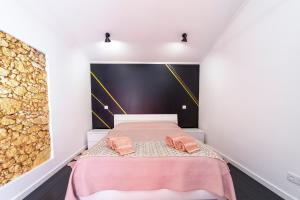 a bedroom with a pink bed with two slippers at Modern Duplex Close to the Beach in Armação de Pêra