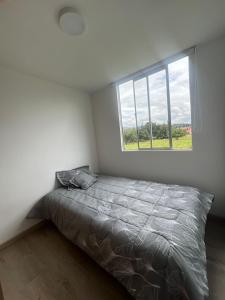 a bedroom with a bed and a window at Apartamento familiar de 3 habitaciones con parqueadero en Paipa in Paipa