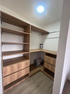a walk in closet with wooden shelves at Apartamento familiar de 3 habitaciones con parqueadero en Paipa in Paipa +3 photos