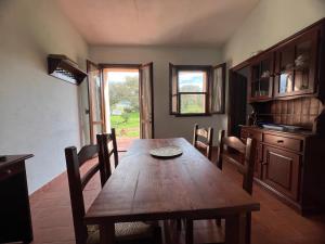 a dining room with a wooden table and chairs at Il Lentischio Casa1 in Nulvi +9 photos