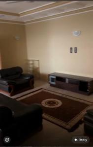 a living room with a flat screen tv and a couch at BUSUMBALA RESIDENTs in Busumbala