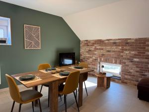 a dining room with a table and chairs and a fireplace at Appartement à Ohain in Ohain