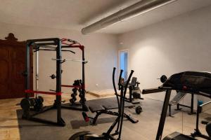 a gym with several tread machines in a room at Villa Rosa Resort in Conversano